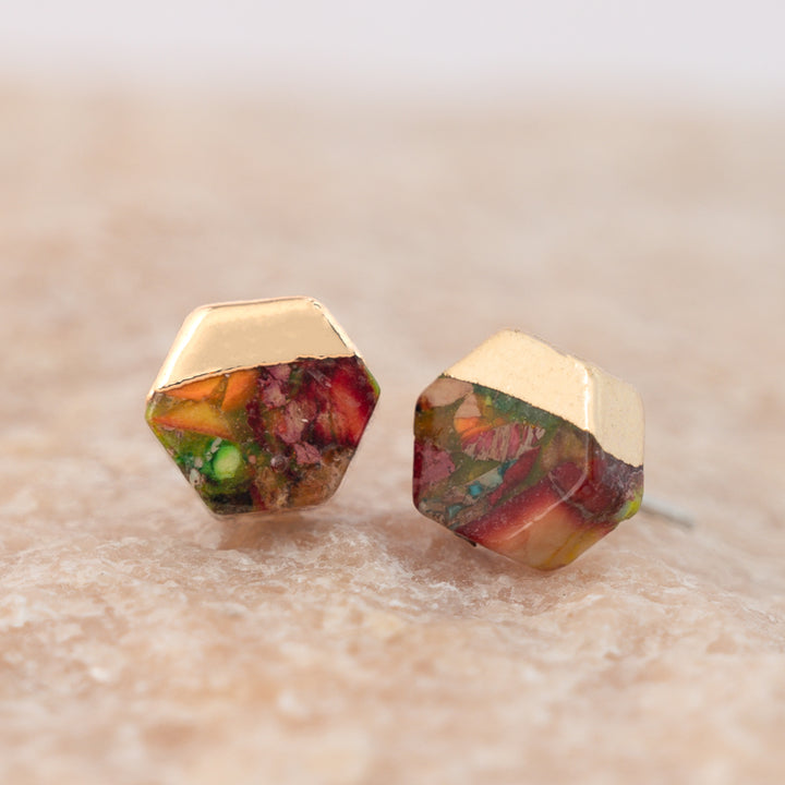 A set of gold and colorful sunrise shaded studs placed on marble platform, home shopping jewelry, women's artisan jewelry presents for xmas