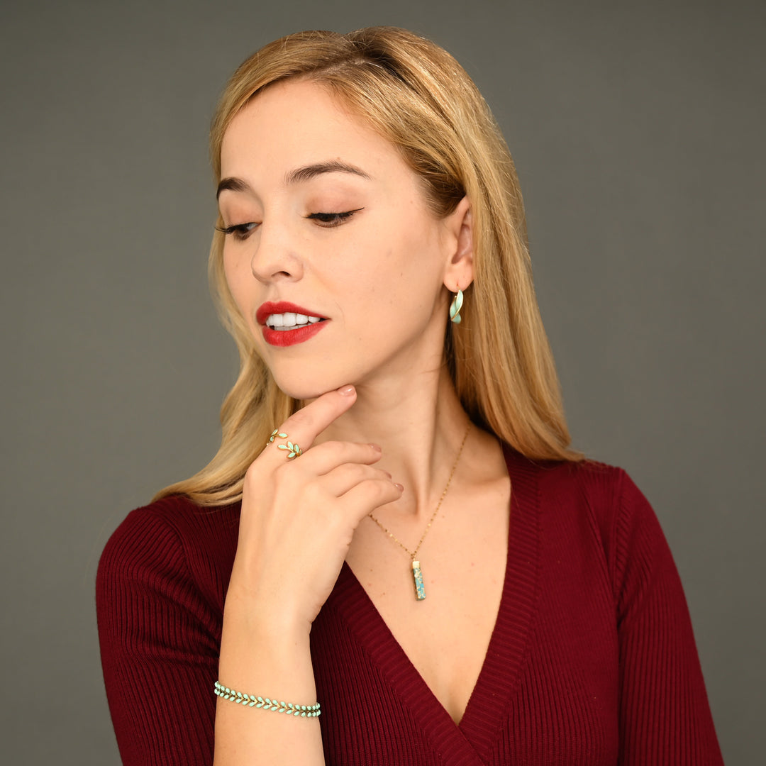 Woman wearing matching mint green and gold jewelry, gold jewelry sets, jewelry pairings, jewelry stores like pandora