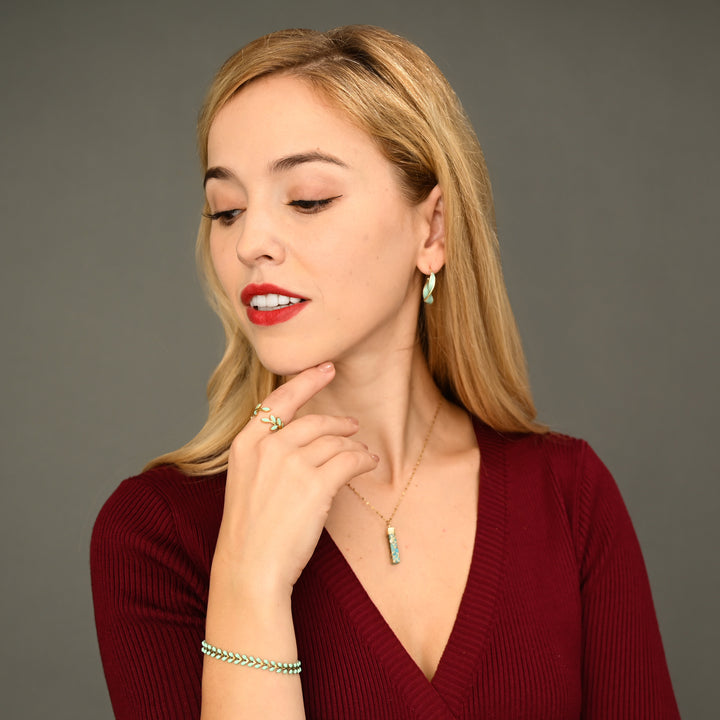 Woman wearing matching mint green and gold jewelry, gold jewelry sets, jewelry pairings, jewelry stores like pandora