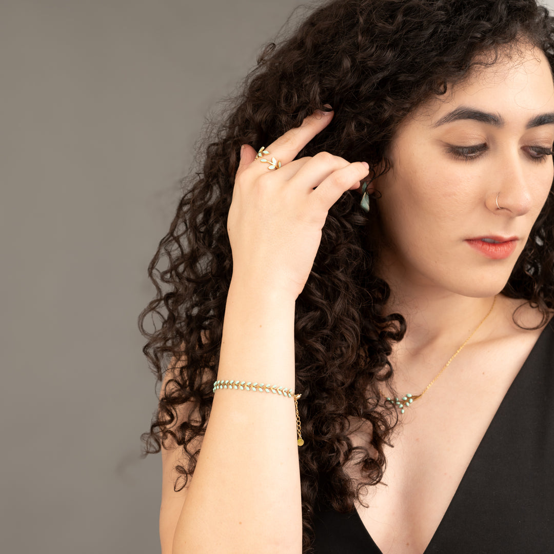 Woman wearing matching seed-shaped jewelry set, mint green and gold jewelry sets, Starfish Project