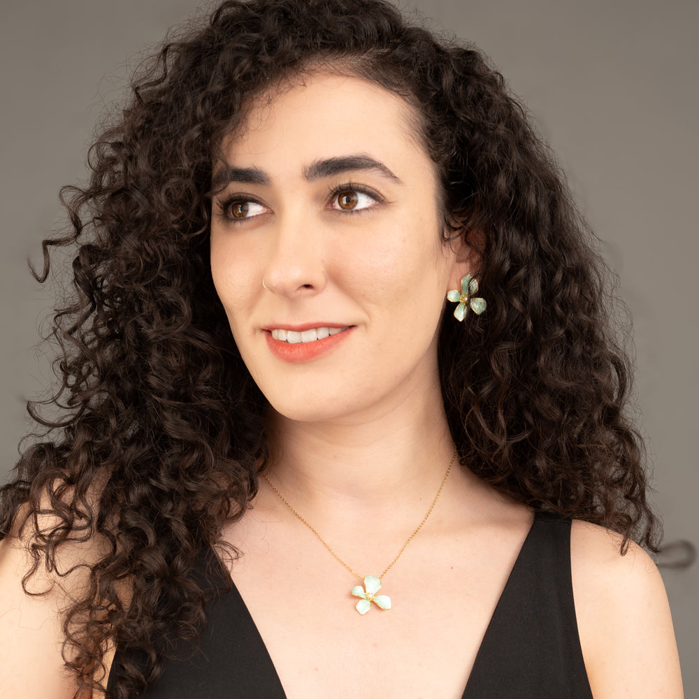 A model wearing matching floral earrings and necklace, matching flower jewelry sets, women's freedom jewelry business