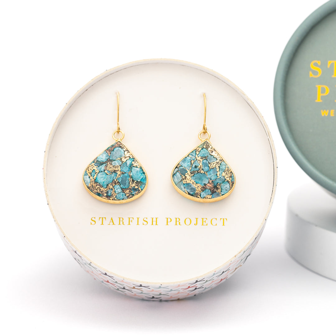 A set of shaded gold and blue emperor stone earrings placed in Starfish Project round gift box, perfect Christmas gift or Mother's day present, fair trade jewelry company, beautiful high quality jewelry