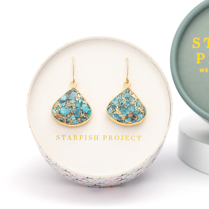 A set of shaded gold and blue emperor stone earrings placed in Starfish Project round gift box, perfect Christmas gift or Mother's day present, fair trade jewelry company, beautiful high quality jewelry