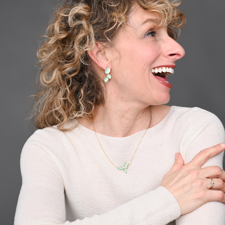 Woman smiling and wearing mint green and gold jewelry, matching necklace and earrings, great xmas present ideas