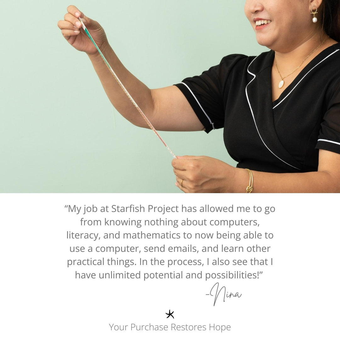 Photo of woman smiling while wearing gold necklace with gold chain, a gold bracelet, and gold earrings with a pearl pendant, women's fair trade artisan jewelry, symbolism of hope, Starfish Project, jewelry website