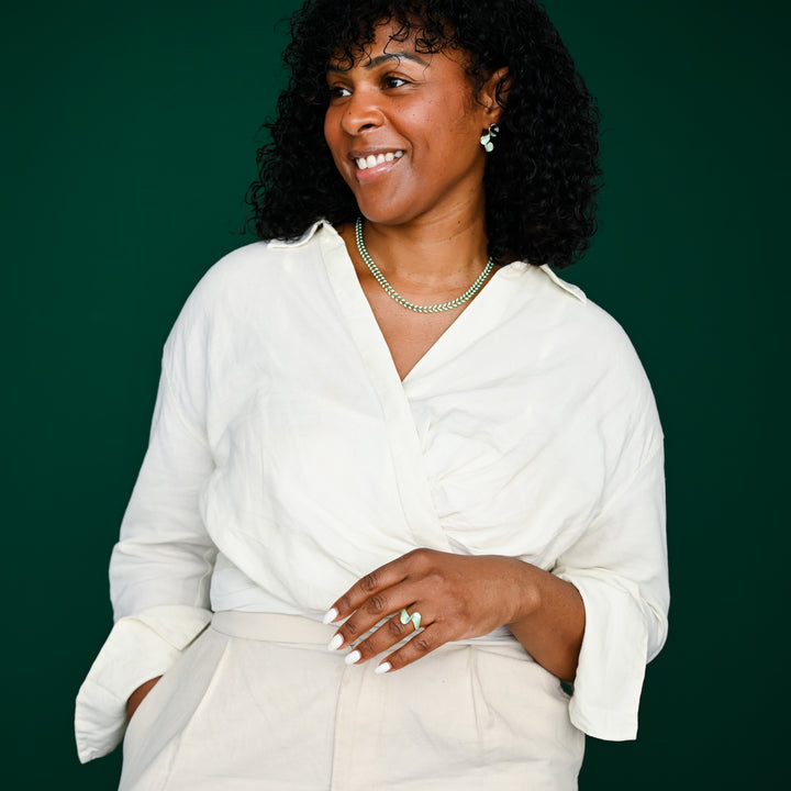 Photo of a woman wearing matching green and gold jewelry pieces, beautiful jewelry sets, artisan jewelry business