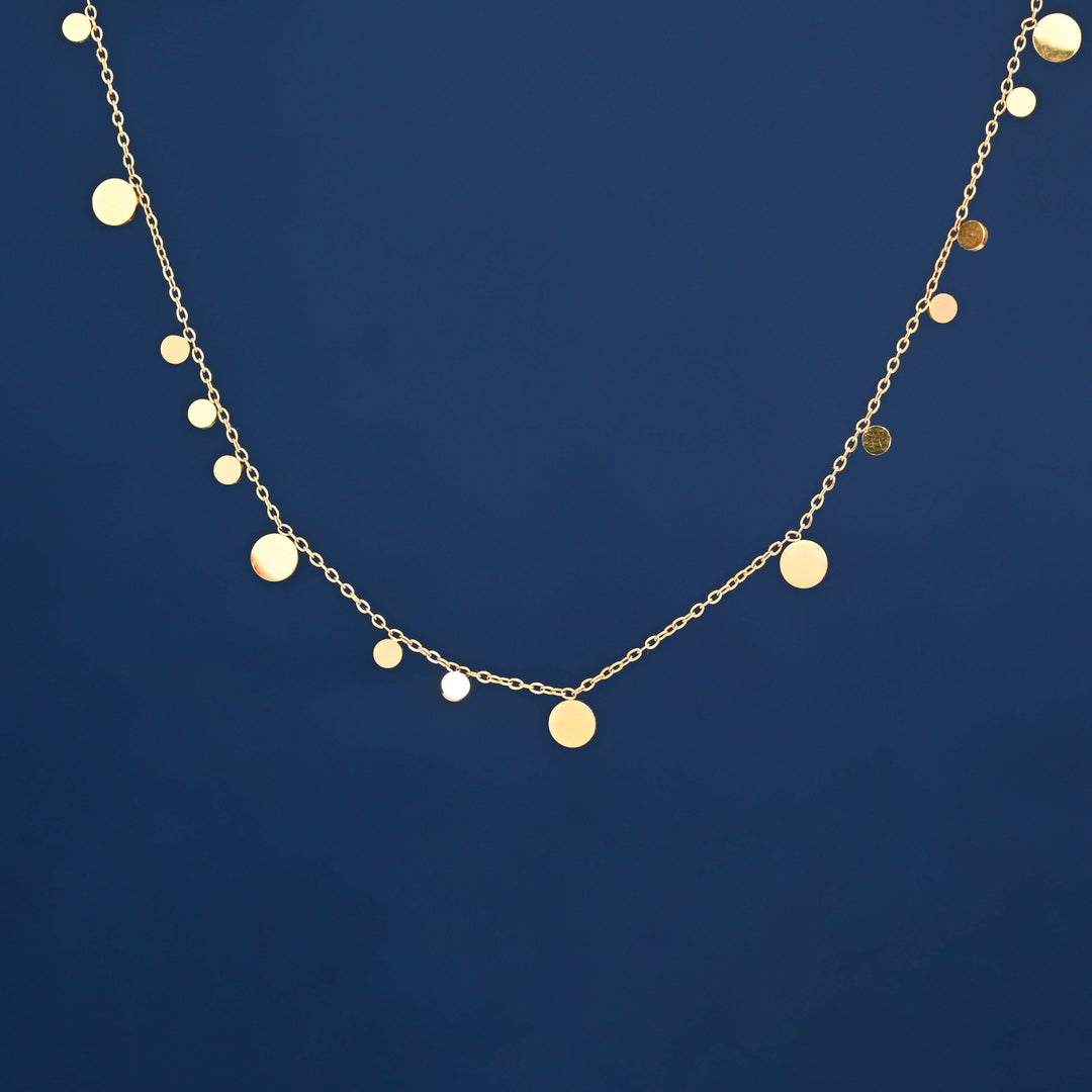 Photo of gold necklace with blue background, gold circles on necklace, ideas for Mother's day