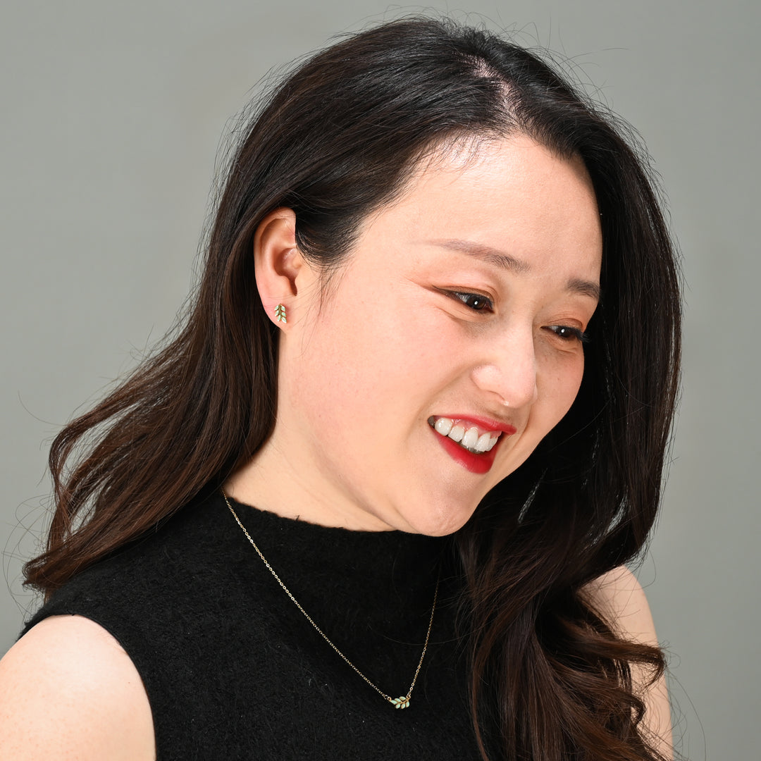 Woman wearing matching earring and necklace set, mint green jewelry, 14k gold jewelry, freedom company near me