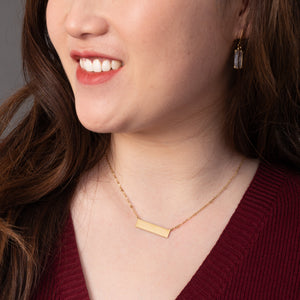 Woman wearing engravable necklace, necklaces with a message, jewelry website, gold bar necklace for women