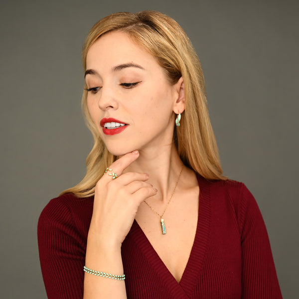 Woman wearing matching mint green and gold jewelry, gold jewelry sets, jewelry pairings, jewelry stores like pandora 