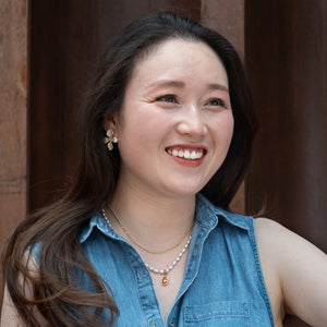 Picture of a woman wearing gold layered necklaces, beautiful gold jewelry, gift ideas for holidays, fair trade gifting business