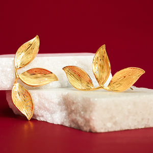 Photo of gold earrings with red background on white marble platform, 14k gold, golden canopy earrings, mother's day presents