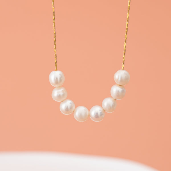 Pearl center gold necklace, simplistic beautiful necklace, best fait trade gifting companies, symbol for hope