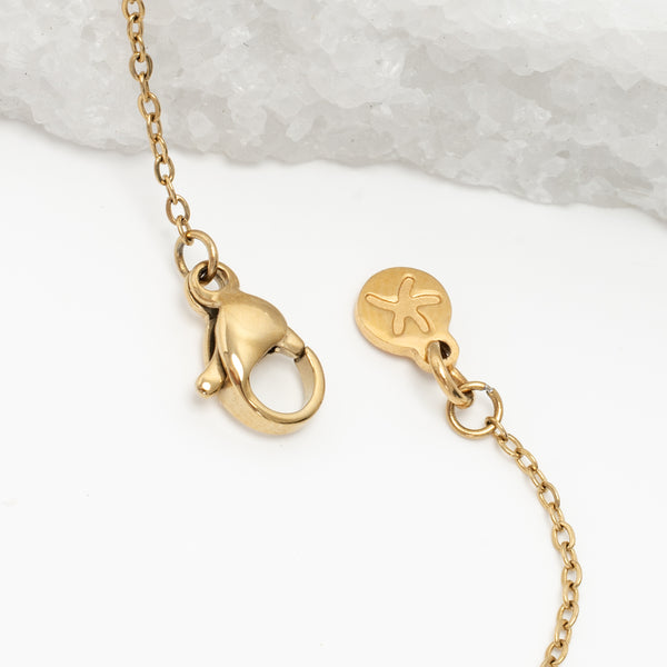 Photo of gold necklace chain, starfish project brand, white and marble background, cute jewelry, high quality necklaces