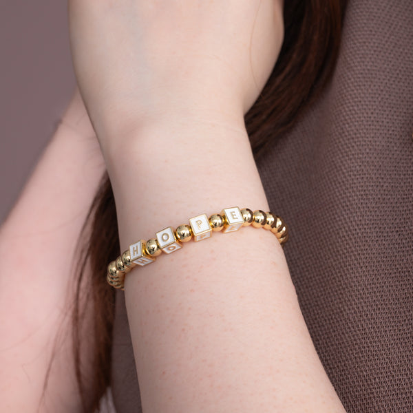 Woman wearing handcrafted gold bracelets, women's artisan jewelry, fair trade business, quality gold bracelet