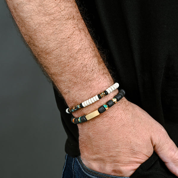 Photo of a man wearing two beaded bracelets, white and black beaded bracelets for men, ocean beaded bracelets for men