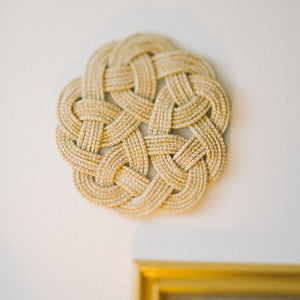 Close up of detailed hand made trivet, women's jewelry and home decor business
