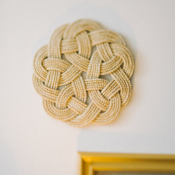 Close up of detailed hand made trivet, women's jewelry and home decor business