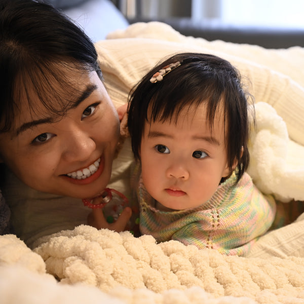 A photo of a mother and daughter in beautifully hand made baby blanket, special mother's day present