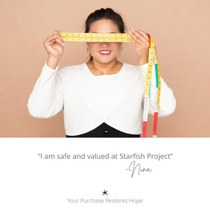 Picture of woman wearing Starfish Project pieces, handcrafted jewelry, symbol of hope, women's artisan jewelry business